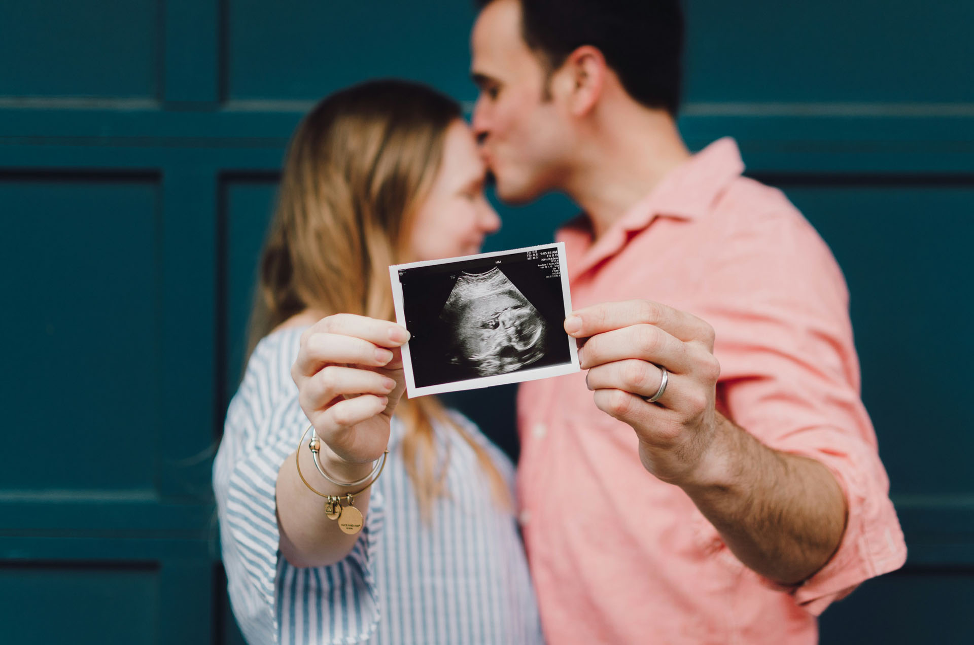 Gravidfotografering i Stockholm där ett blivande föräldrapar håller upp en ultraljudsbild framför kameran. Paret står tätt tillsammans och fokuset ligger på ultraljudsbilden som symboliserar väntan på familjens nya medlem.